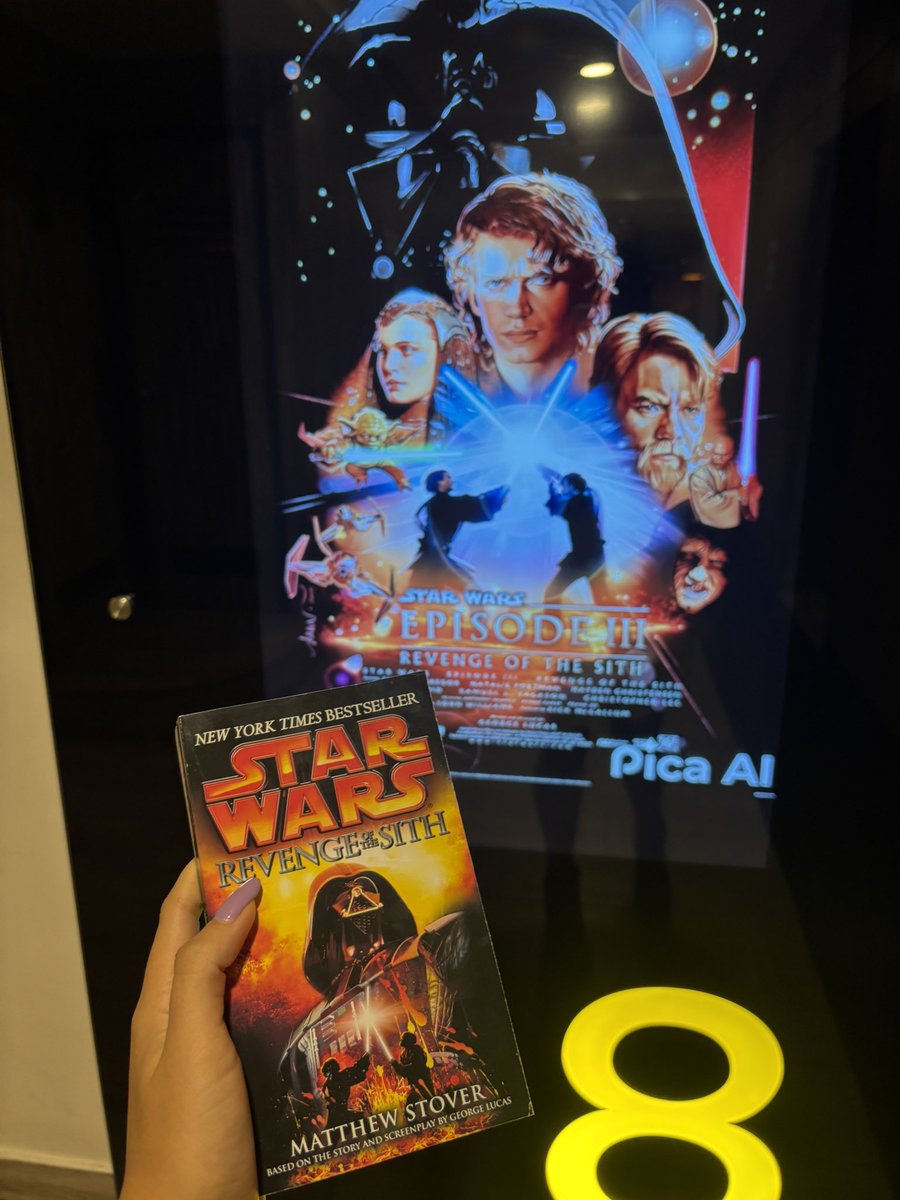 A picture of my hand holding the rots novelization in front of the rots poster
