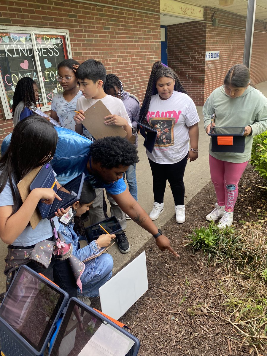 Students engaged in an Ecosystem scavenger hunt documenting with pictures to present through Keynote.