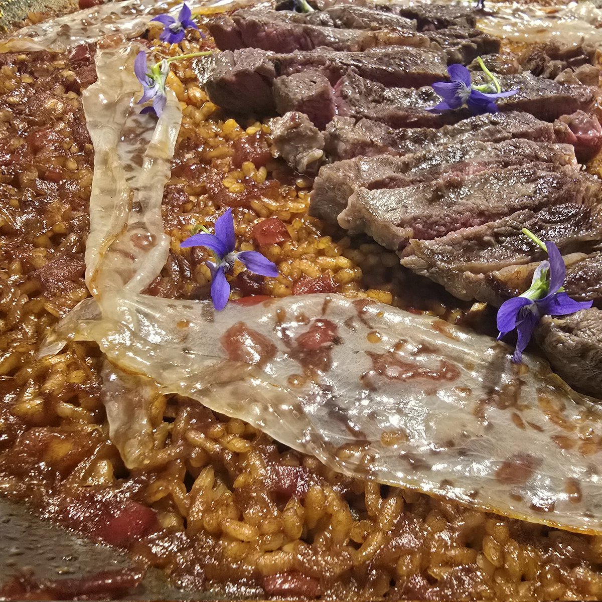 Paella de chuleta de vaca, velo de papada ibérica y violetas.

#homemade #homefeito #nacasiña