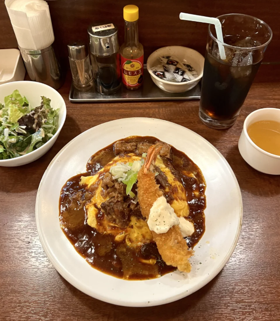 おいしそうな和食です!なめらかな玉子焼きにコクのある牛ソースをかけ、カリッとしたエビフライを添えて、味蕾(みらい)を楽しませます!さっぱりとしたサラダと冷たいコーラが添えられています。一番好きな和食は何ですか。🥰