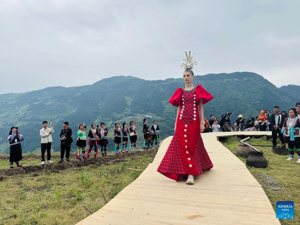 On a wooden runway built in the terraced fields of Jiabang in southwest China's Guizhou Province, Miao ethnic villagers, dressed in their finest attire, stepped forward to present a new fashion show featuring intangible cultural heritage.