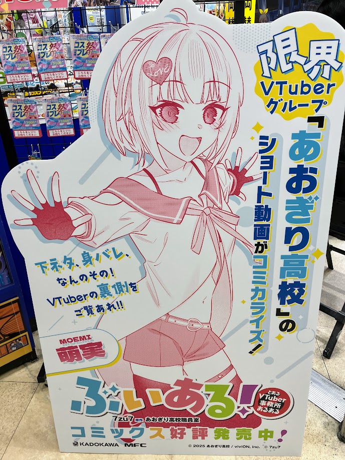 【コミック販売情報】
 #ぶいある! ～とあるVTuber事務所あるある～ コミック2巻が本日発売です！

購入特典として、イラストカードが付いてきます！
新刊発売を記念して当店ではスタンディを展開中！ご来店の際には是非ご覧下さいませ！