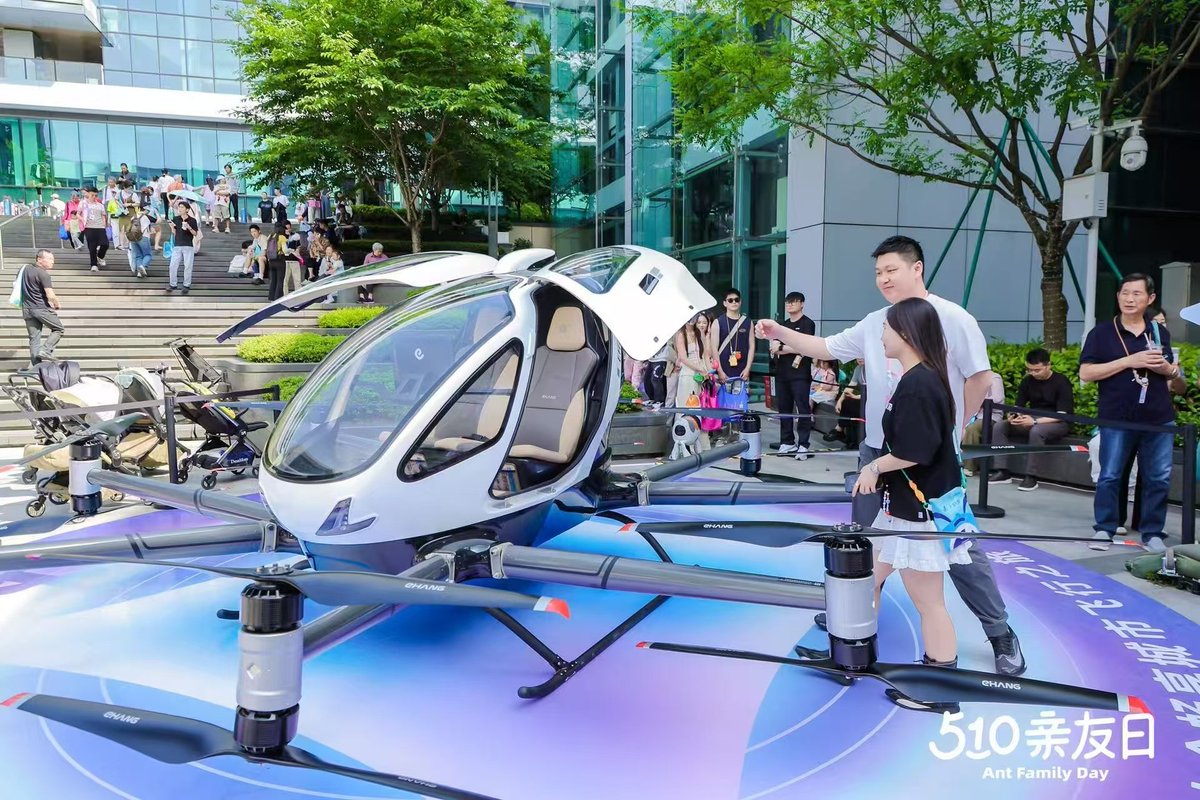 ehang's tweet photo. 🚁 The world's first manned autonomous aircraft available on Taobao just made a splash at @AntGroup Ant Group's 510 Family & Friends Day!

The EHang EH216-S eVTOL stole the spotlight, turning heads and capturing imaginations. ✨

Guests gathered to check out the design and smart technology behind this 'flying car', take photos and imagine a future where low-altitude air travel is part of everyday life. 📸🚁

This isn't just a technology showcase - it's a glimpse of what's possible.
As cities move towards smarter and greener mobility, eVTOLs like the EH216-S are redefining how we move through the skies.

We were thrilled to showcase the EH216-S at the event and give people a real taste of tomorrow's travel.The event was buzzing with excitement as Ant Group employees brought their families to check out the flying vehicle firsthand, creating a truly vibrant atmosphere! 🎉

If you had a flying vehicle like this, how would it change your commute? 🤔

#EHang #EH216S #eVTOL #FutureMobility #LowAltitudeEconomy #TaobaoLaunch #FlyingCars #SmartTravel #UrbanAirMobility #AntGroup51
