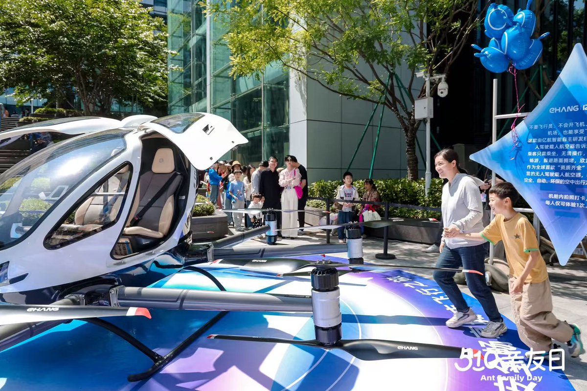 ehang's tweet photo. 🚁 The world's first manned autonomous aircraft available on Taobao just made a splash at @AntGroup Ant Group's 510 Family & Friends Day!

The EHang EH216-S eVTOL stole the spotlight, turning heads and capturing imaginations. ✨

Guests gathered to check out the design and smart technology behind this 'flying car', take photos and imagine a future where low-altitude air travel is part of everyday life. 📸🚁

This isn't just a technology showcase - it's a glimpse of what's possible.
As cities move towards smarter and greener mobility, eVTOLs like the EH216-S are redefining how we move through the skies.

We were thrilled to showcase the EH216-S at the event and give people a real taste of tomorrow's travel.The event was buzzing with excitement as Ant Group employees brought their families to check out the flying vehicle firsthand, creating a truly vibrant atmosphere! 🎉

If you had a flying vehicle like this, how would it change your commute? 🤔

#EHang #EH216S #eVTOL #FutureMobility #LowAltitudeEconomy #TaobaoLaunch #FlyingCars #SmartTravel #UrbanAirMobility #AntGroup51