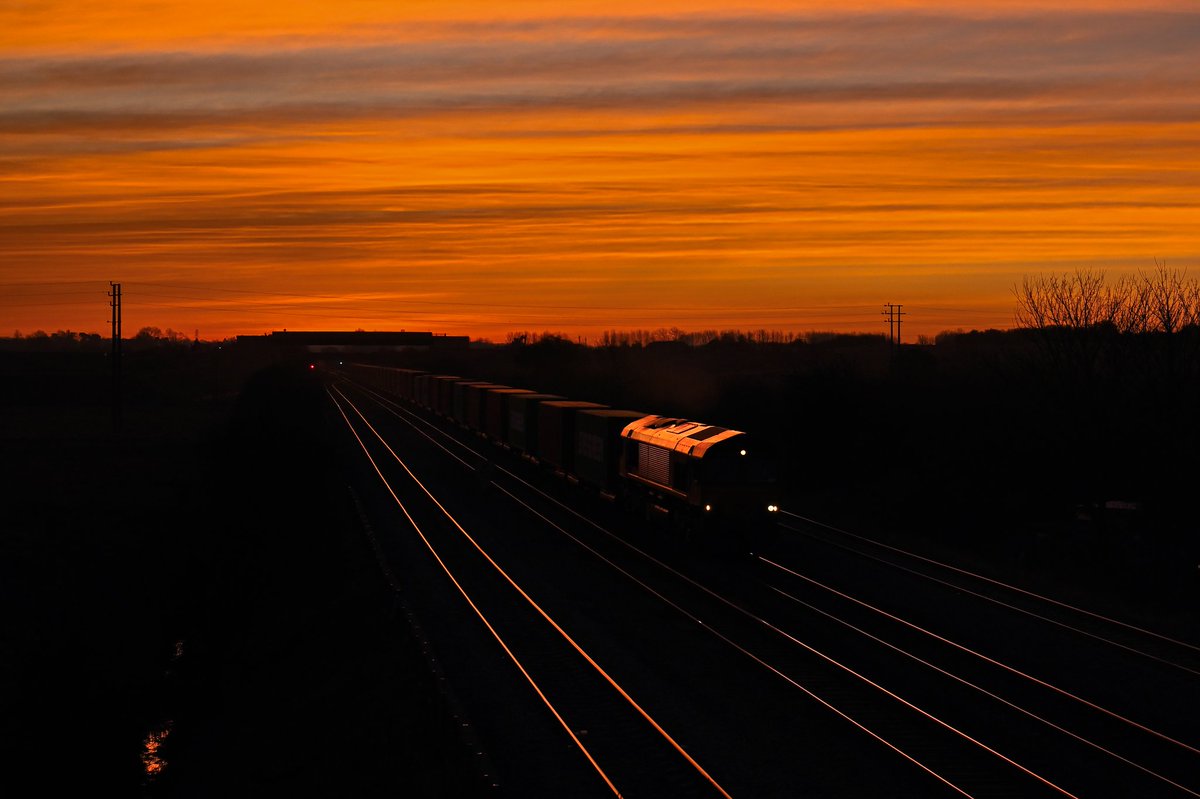 Shed Sunrise.

66015 creeps towards Melton Mowbray just moments before sunrise on 5th March 2025, working the 4M34 Felixstowe to East Midlands Gateway. A slight detour on my way home from a night shift, in the hope that a passing train would coincide with this breathtaking scene!