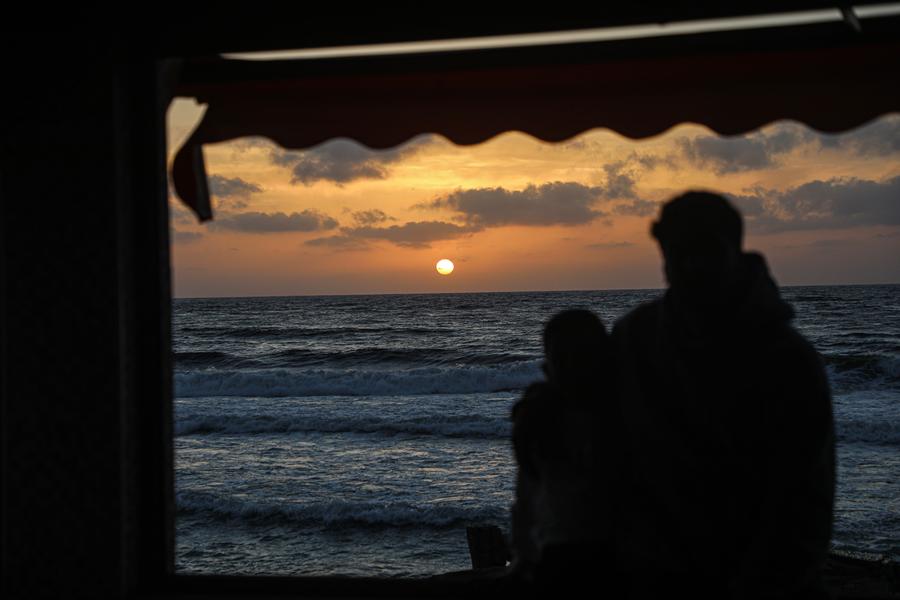 فلسطينيون يقضون وقتا طيبا على الشاطئ أثناء غروب الشمس في مدينة غزة، يوم 12 مايو 2025.