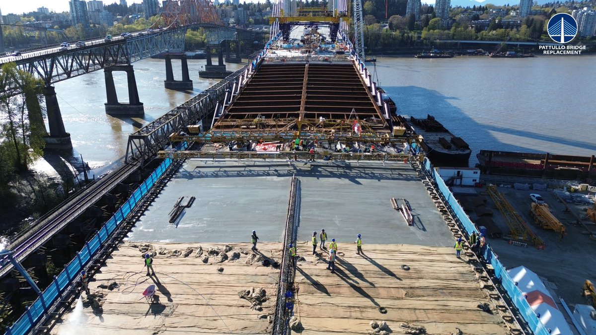 Here’s a close-up of April’s final concrete deck pour for the south approach.

The light grey concrete seen in the middle of the photo is freshly poured concrete. Near the bottom of the photo, burlap covers newly poured concrete to support the curing process.