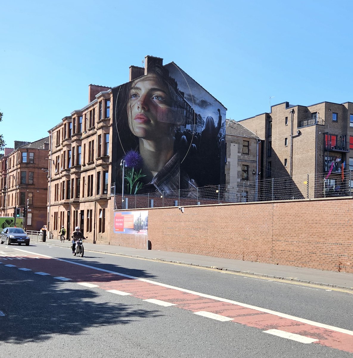 New mural on gable of 1198 Govan Road is stunning! People in crowd are holding a banner that reads "Affordable housing is a right", the girl symbolises a modern Mary Barbour. 
The mural is by artist Jeks and was commissioned to mark the 50th anniversary of <a href="/LinthouseHA/">Linthouse Hsg Assoc</a>