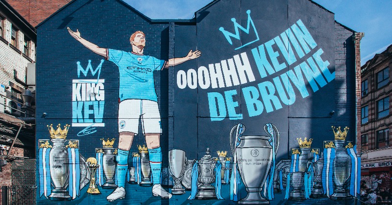 ManCity's tweet photo. King Kev's iconic mural unveiled 👑

The installation which started on Monday morning and completed on Wednesday afternoon, features every trophy he has won during his 10 years at City 🏆