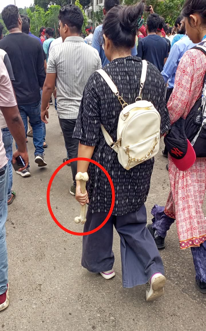 Ebrahim_khalid_'s tweet photo. Nearly nine months since the uprising, here I show you an image of a woman—carrying a femur, perhaps from her medical studies, perhaps from a life paused—walking toward the historic gathering at Shahid Minar on July 34, 2024. https://t.co/jnnRpFg6Pi