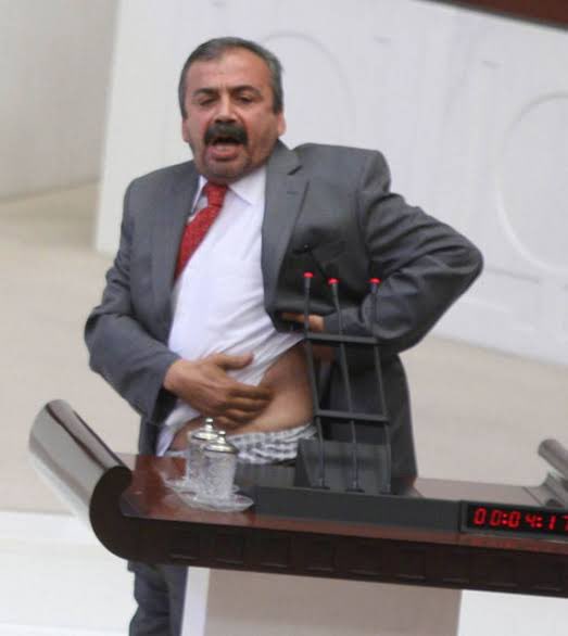 Dalga geçtikleri bu fotoğrafın tarihi 10 Temmuz 2013.

Sırrı Süreyya Önder mecliste konuşma yaparken, Gezi Parkı’nda polisin kendisine sıktığı plastik mermilerin izlerini gösteriyor ve halka uygulanan şiddeti gündeme getiriyor.

Kutsal olan onurlu ve haysiyet sahibi bir yaşam,