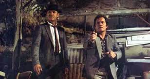 merlinpapin3's tweet photo. .@FredOL69007 #DéfiCinéClassique2025 Mai avec le film #FrenchConnectionII de John Frankenheimer (1975) avec Gene Hackman Bernard Fresson Fernando Rey Samantha Llorens Reine Prat Philippe Léotard Alexandre Favre Jean Pierre Castaldi Raoul Delfosse Charles Millot

Enlevé à Marseille par Alain Charnier, le chef de l'organisation, Popeye Doyle est drogué contre son gré et laissé dans un état de décrépitude totale. Libéré, il entreprend une cure de désintoxication avec ses propres méthodes avant de combiner ses forces à celle d'un collègue français pour retrouver la trace de Charnier.

French Connection II n’est pas une simple suite hollywoodienne opportuniste. C’est une extension rugueuse, presque déviante, du chef-d’œuvre de William Friedkin (1971), qui choisit de ne pas rejouer la même partition, mais de plonger son héros dans une autre dimension — géographique, psychologique et humaine. Exit les rues grises de New York, place à la lumière brutale et trompeuse de Marseille, ville étrangère, labyrinthique, où l’inspecteur Popeye Doyle (Gene Hackman) est littéralement largué.

L’histoire reprend là où s’arrêtait le premier opus. Doyle, toujours obsédé par le baron de la drogue Alain Charnier (Fernando Rey), est envoyé à Marseille pour participer à une traque internationale. Mais il est vite isolé, incompris, frustré par les méthodes de ses homologues français, notamment le commissaire Barthélémy (incarné par un excellent Bernard Fresson), qui tente tant bien que mal de composer avec ce bulldozer américain en terre inconnue.

Mais Frankenheimer choisit un virage radical : ce n’est pas l’action qui prime ici, mais l’humiliation, la déchéance, la lutte intérieure. Doyle, enlevé par les hommes de Charnier, est drogué à l’héroïne pendant plusieurs jours. S’en suit une longue séquence de sevrage, douloureuse, organique, presque insupportable — une des plus puissantes de la carrière de Hackman. Ce n’est plus un flic aux nerfs d’acier que l’on suit, mais un homme vidé, humilié, réduit à l’état d’enfant hurlant et transpirant sur un matelas pourri.

C’est dans ce gouffre que le film trouve son originalité et sa force. Le Doyle nerveux, impulsif, sûr de lui du premier épisode devient ici un survivant, un homme qui, sans jamais perdre sa rage, doit apprendre à marcher de nouveau — au propre comme au figuré. La relation ambivalente entre lui et Barthélémy, mélange de méfiance et de respect, constitue le fil émotionnel du récit, donnant lieu à quelques très belles scènes d’humanité cachée sous les dehors d’un polar dur.

Certes, French Connection II n’a ni la musique entêtante de Don Ellis, ni les poursuites spectaculaires du film original. Les rues de Marseille sont moins cinégéniques que les métros new-yorkais, et Frankenheimer filme sans esbroufe, avec une forme de sécheresse quasi documentaire. Mais cette austérité fait mouche. Il capte une ville rugueuse, sale, humaine, grouillante, magnifiée par une distribution française impeccable : Jean-Pierre Castaldi, André Penvern, Charles Millot, tous participent à ancrer ce récit dans une France très 70s, faite de terrains vagues, de ports rouillés et de commissariats fatigués.

La dernière partie du film, plus nerveuse, où Doyle, sobre, traque Charnier dans les docks, apporte une conclusion satisfaisante, tendue, violente. Elle n’efface pas les moments d’égarement, mais les justifie, les parachève. Hackman, Oscarisé pour le premier volet, va ici encore plus loin dans la construction d’un personnage brisé, cabossé, mais tenace. Rarement un héros de polar aura semblé aussi vulnérable, et donc, paradoxalement, aussi humain.

French Connection II n'est pas une suite à la hauteur du premier sur le plan de la mise en scène ou du rythme, mais c’est une proposition singulière et courageuse. Frankenheimer transforme le thriller en étude de personnage, offrant à Hackman un rôle d’une grande amplitude dramatique. Le changement de décor, les seconds rôles français très typés et l’approche presque clinique de la dépendance en réalisent un film à part, moins culte peut-être, mais tout aussi digne. Une suite amère, rugueuse, et profondément marquante.
