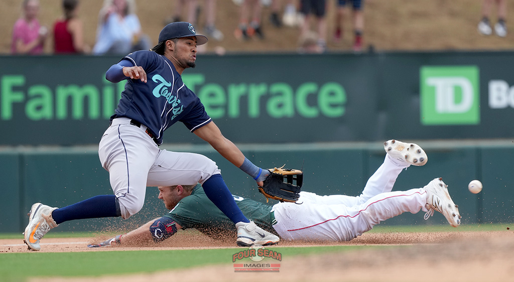 Brooks Brannon (5) of the Greenville Drive slides headfirst into third base with a triple as Cristian Gomez (13) of the Asheville Tourists awaits the throw in a South Atlantic League game on Sunday, May 4, 2025, at Fluor Field in Greenville, S.C. (Tom Priddy/Four Seam Images)