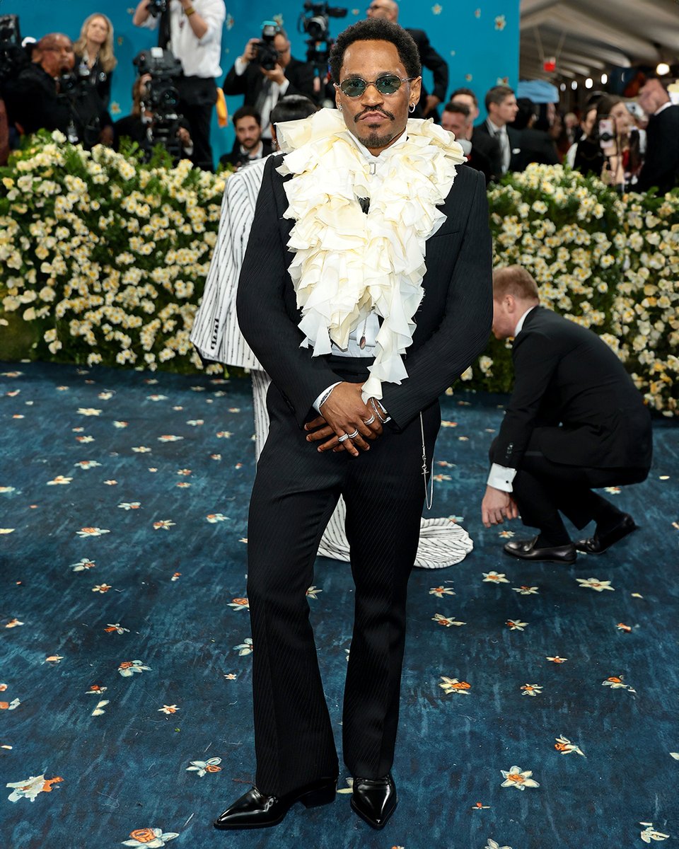 McQueen's tweet photo. Kaytranada wears custom McQueen Autumn Winter 2025 to the 2025 #MetGala.​

A shrunken tailored jacket and kickback trousers in black exaggerated cavalry wool twill. Tuxedo shirt in white cotton poplin and layered collar in ivory washed silk, organza and georgette.​

Worn with Heron Oxfords in black leather and Metal T-Bar Oval sunglasses.