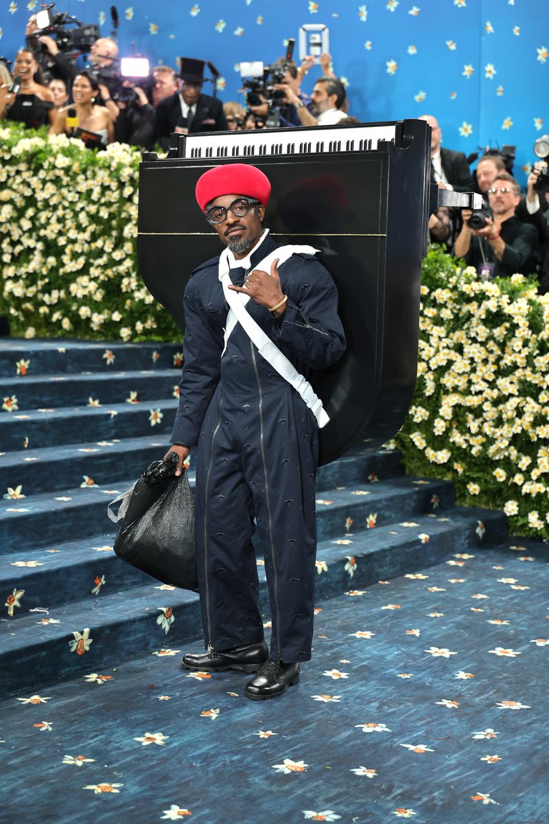 Spotify's tweet image. André 3000 climbing up the #MetGala stairs with a piano on his back—call us impressed.