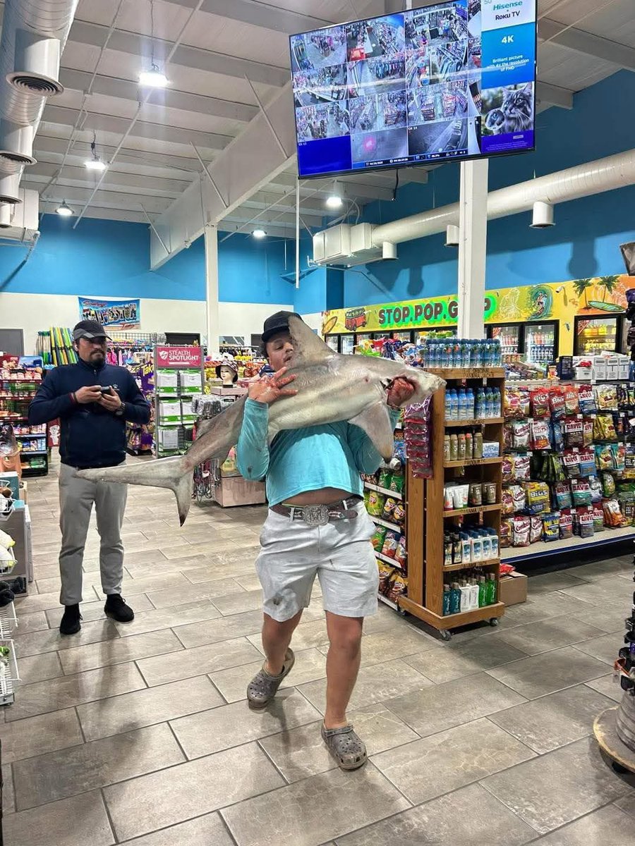 Only in Galveston you will see someone holding a shark in a gas station