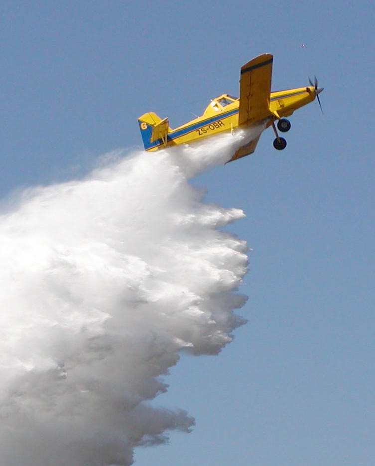Fire bomber!
Helicopters aren’t the only aircraft used in aerial fire-fighting in South Africa. Here a turboprop Thrush displays a fire-fighting drop for an excited crowd at an airshow.
Nelspruit Airfield, Mpumalanga, 2002.
Photograph by Raymond Travers