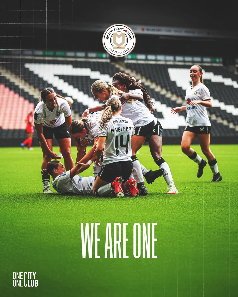 A graphic featuring the new MK Dons crest and bold white text that reads 'We Are One' over an image of MK Dons Women celebrating a goal at Stadium MK.
