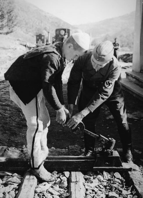 AlbaniHistorian's tweet photo. Mitrovica, 1943: A German officer trains a young Albanian worker on how to change tracks on the railway. https://t.co/auUzAfSWbq