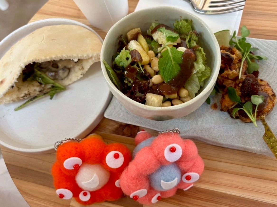pirororo11's tweet photo. バーレーン館🇧🇭入館後、出口手前にカフェ。食べ物はイートインのみ。左がタラの選択(ビーフサンド。タラはシェフの名前のようです？)2700円と右がAセット(サラダとエビ2匹の串焼き)2500円。美味しいけど小ちゃいから３倍食べたい🤤イスがビヨンビヨンして斬新なデザインでかわいい🩵 https://t.co/x0UiTezFAP