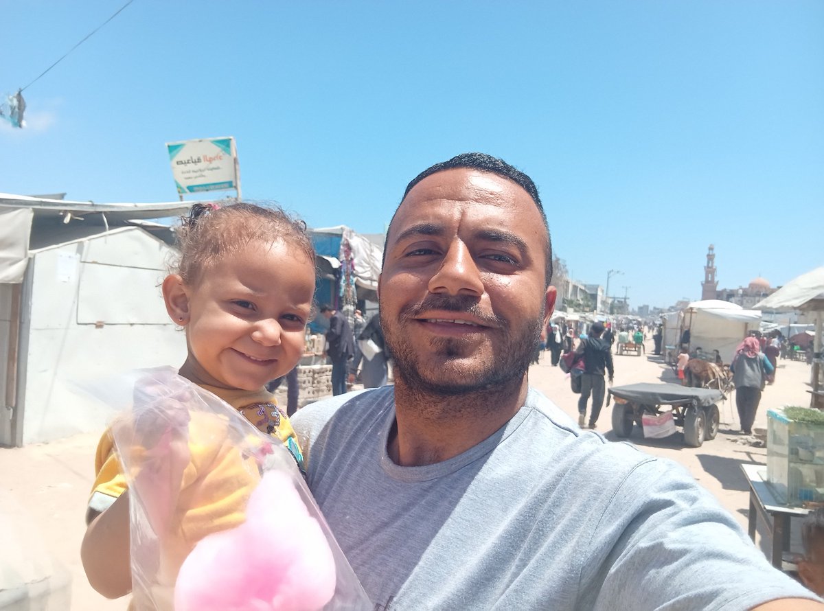 Between Ghada’s smile and the misery around us, there’s a destroyed market and a war that left us with nothing.  
We’re not living — we’re just surviving.

Ghada is smiling, but her body is weak, and her health is getting worse.  
There’s no food, no medicine, no safety.  
I