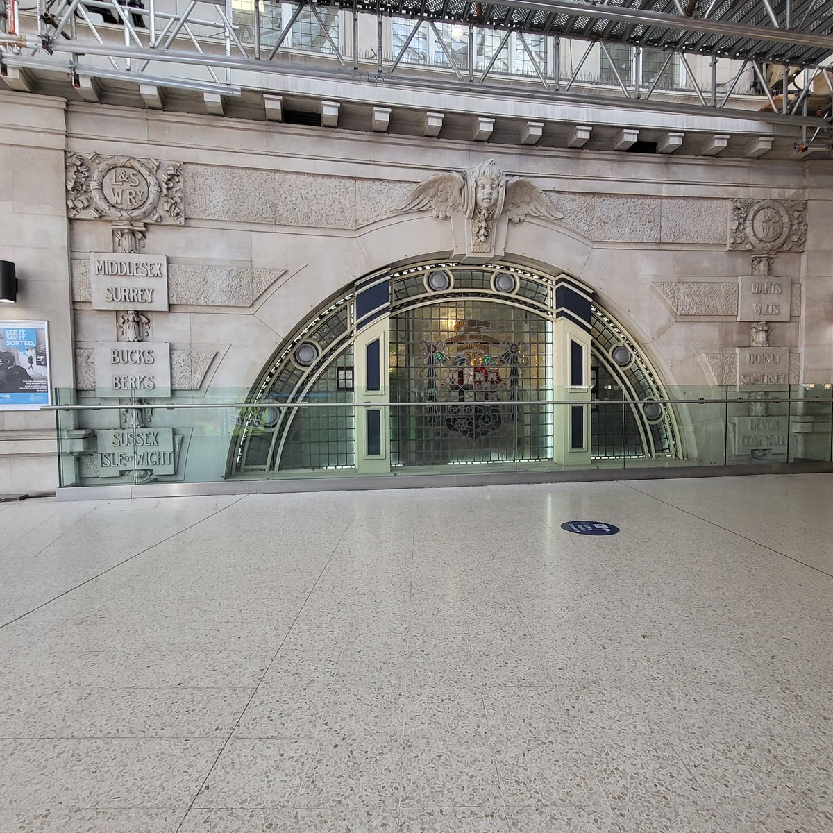 RichTheGuard's tweet image. Waterloo always has some building work going on, but some historic markers remain, such as this stained glass and stones, on the mezzanine,  showing the counties that the London and South Western Railway and its modern-day equivalents serve, some not so much anymore