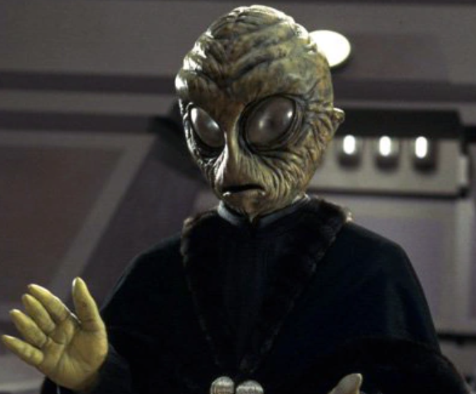 Just noticed that the Aurebesh identifies this senator in Andor as Den Gane from Roona, making him a likely relative of the Roonan Senator Edcel Bar Gane from The Phantom Menace.