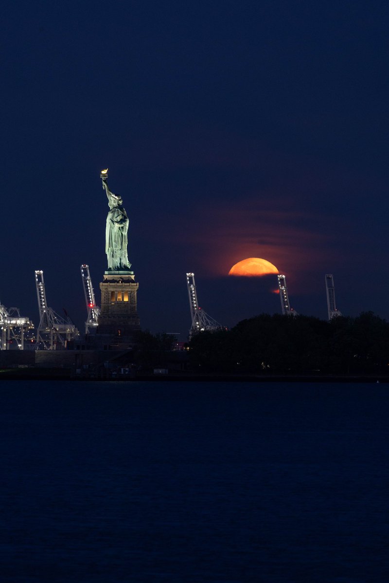 Max Guliani (@maximusupinnyc) on Twitter photo Full Flower Moon setting over Liberty Island, seen this morning from Battery Park #NYC Full Flower Moon setting over Liberty Island, seen this morning from Battery Park #NYC