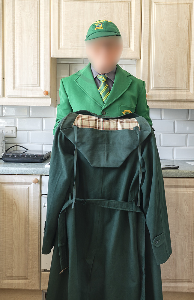 The boy with his junior schoolgirl's raincoat.