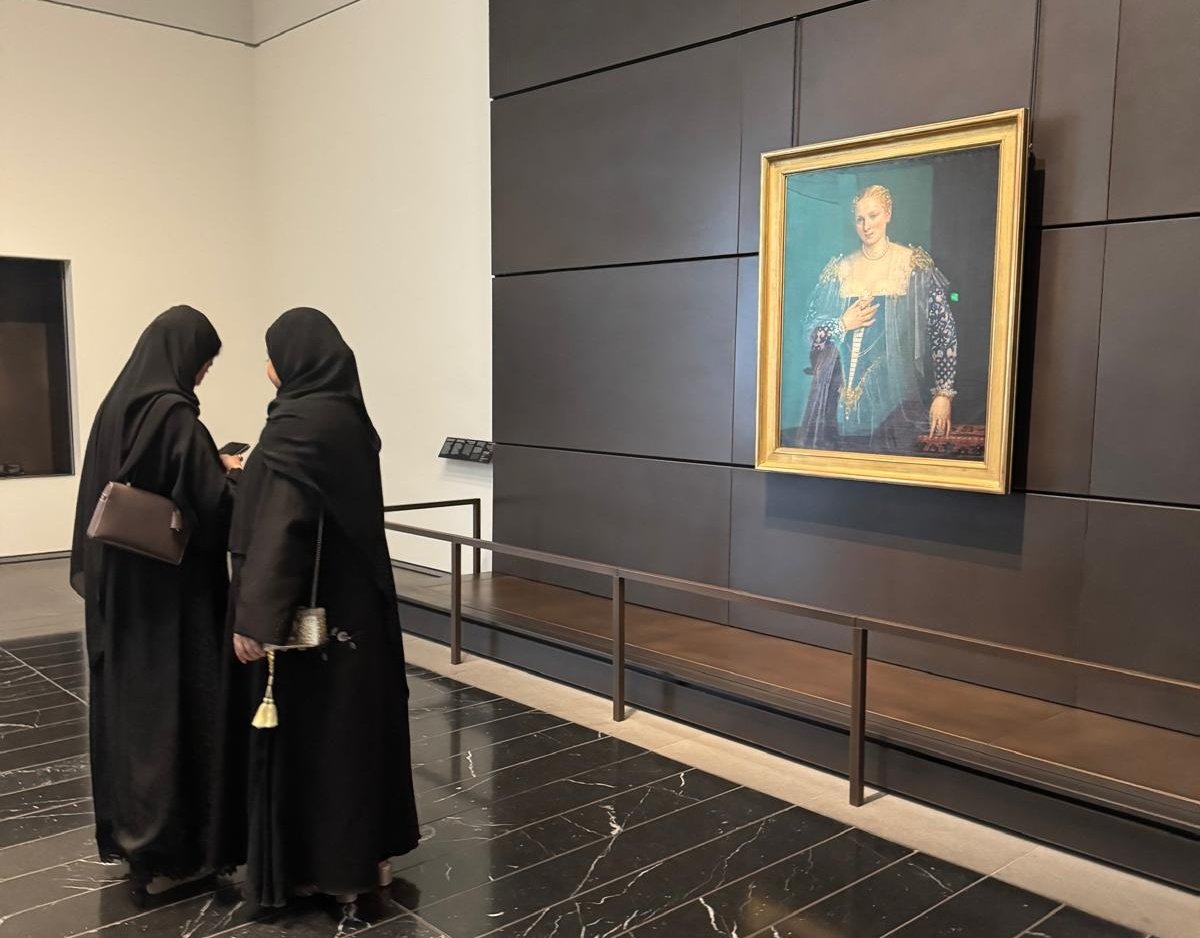 Duas mulheres curiosas tiram fotografias a um retrato europeu. O ligeiro decote reflete bem o pudor da época.  O óleo veneziano é de 1560. As mulheres são de 2025.
