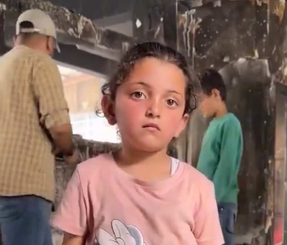 Ward flieht durch die Flammen einer von Israel zerstörten Schule – ein Kind, das durch den Tod rennt. 36 Seelen verbrannten dort, 18 davon waren Kinder. Nur sie und ihr Vater überlebten. Und die Welt? Sie schweigt – feige, kalt. Ein Schweigen, das mit den Bomben schreit.