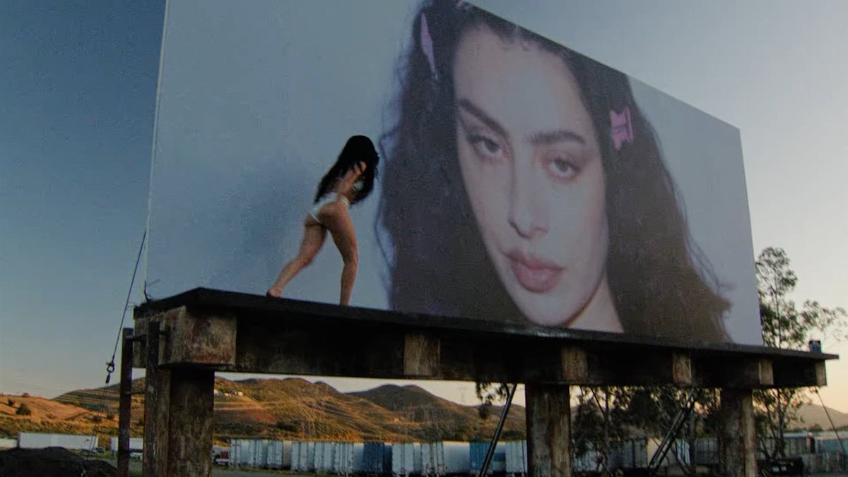 PopCrave's tweet photo. Charli xcx lights billboard of herself on fire in the “party 4 u” music video. https://t.co/0NDmmcTOJ5