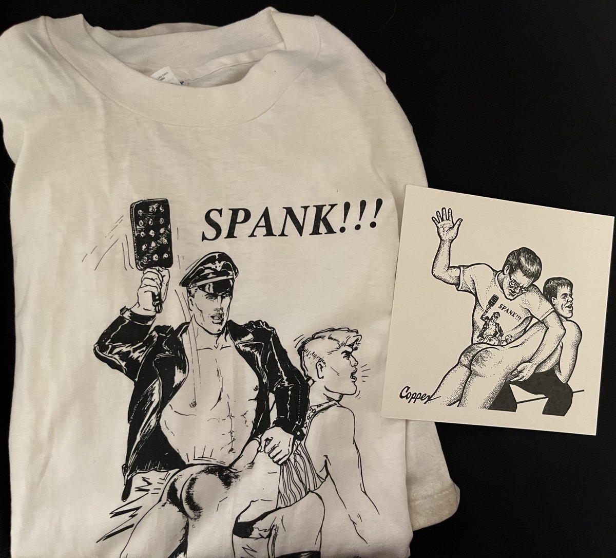 It’s 6 days to the opening of, “Paddles and Switches and Straps, Oh My! The Dynamic Community of Adult Male Spanking.” Come by the Leather Archives &amp; Museum for a reception on May 22, 7pm. Enjoy this 1996 Camp Red Tails shirt, and a drawing by Copper showing a spanker wearing it!