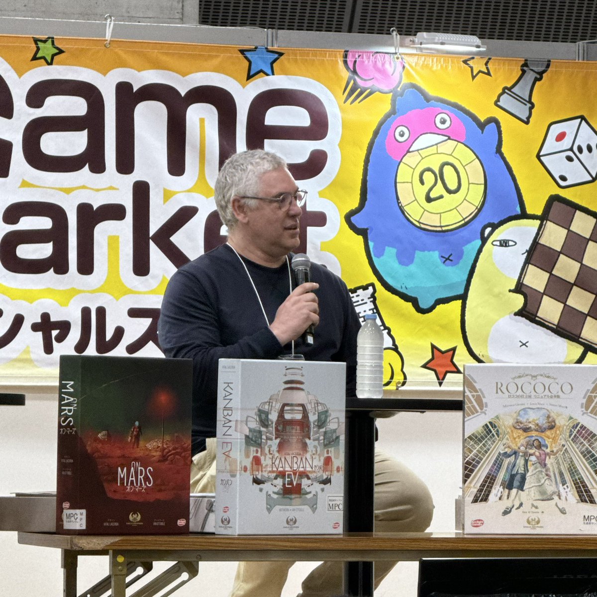 ラセルダ先生 <a href="/vitallacerda/">Vital</a> のスペシャルステージ。ワレスさんの蒸気の時代を遊んでボードゲームデザインに目覚めたそう！ KANBANの秘書サンドラさんは奥さんでした。会場席の一番後ろに座ってます。
#ゲームマーケット2025春 
#VitalLacerda