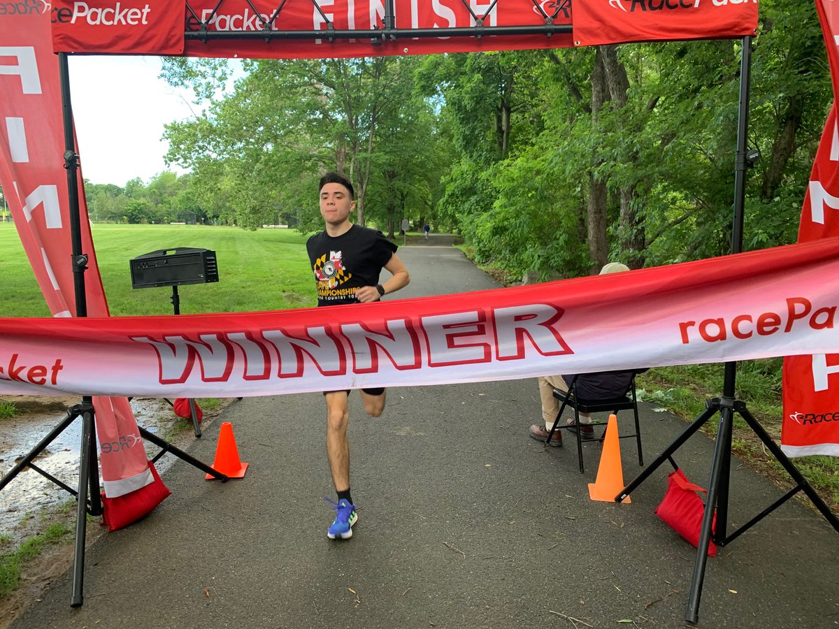 RacePacket's tweet image. Alex breaks the winner’s tape at Run For Ukraine 5K