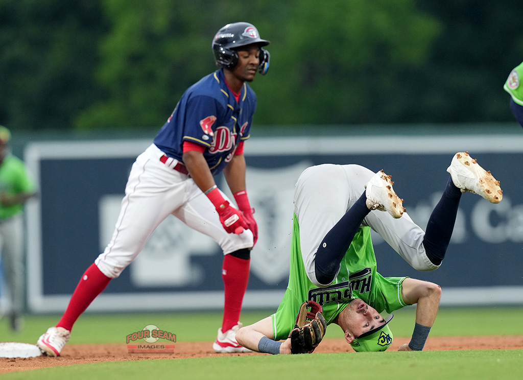 Second baseman Theo Hardy (5) of the Hub City Spartanburgers loses his balance and falls backward after tagging out Andy Lugo (36) the Greenville Drive in a South Atlantic League game on Friday, May 16, 2025, at Fluor Field in Greenville, S.C. (Tom Priddy/Four Seam Images)