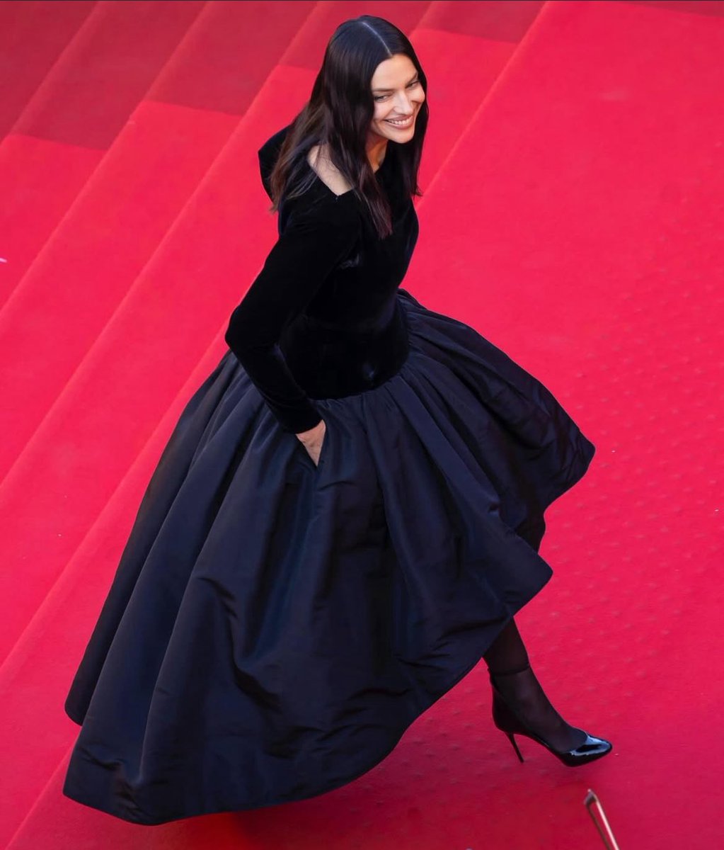 Jessie graces the red carpet at Cannes wearing vintage YSL from the winter 1989 collection, a stunning black velvet gown, with an undulating faille skirt and boatneck, sheer tights, and black stiletto pumps