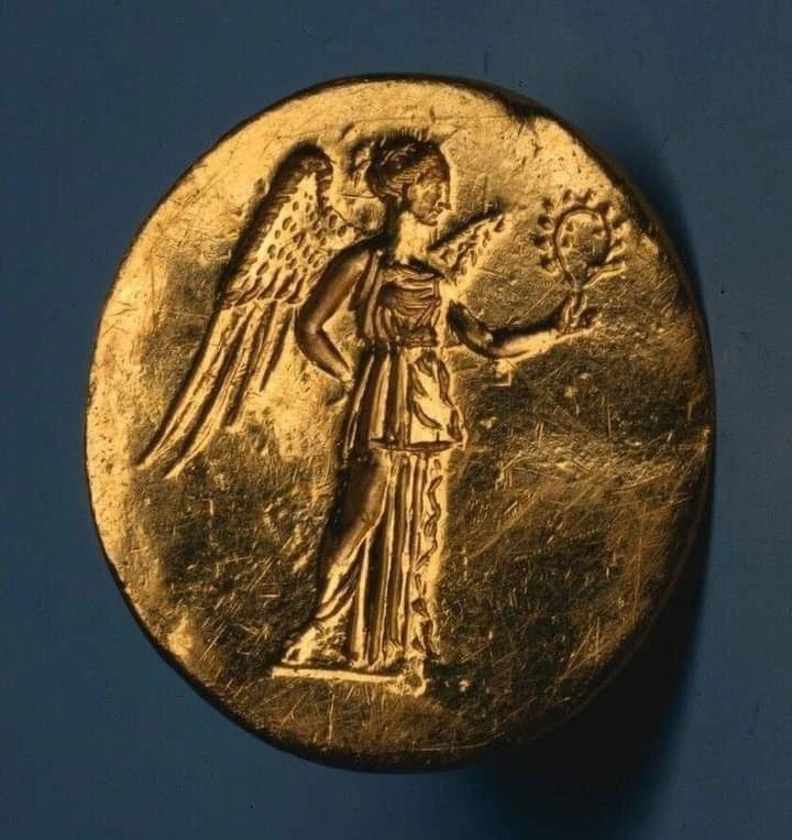 Эллинская золотая монета IV века до н.э.,
Богиня Победы Ника с лавровым венком, соответственно, победителя. 
С крыльями. Христиане не особо смущаясь взяли образ для своих ангелов.