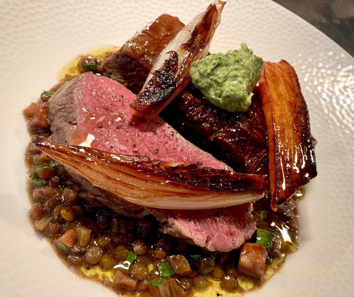 Slow-roast short-rib with a slice of chateaubriand, lentils braised in the beef juices, a punchy salsa verde and shallots.