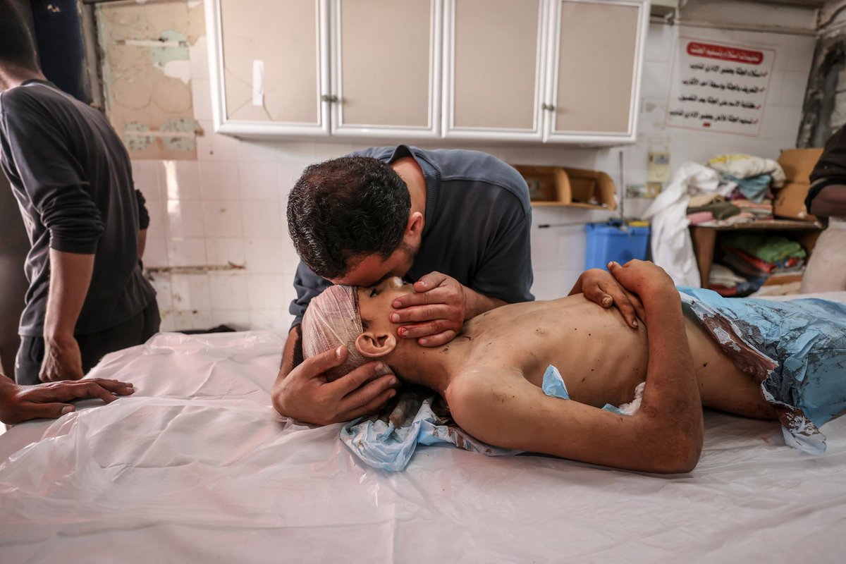 Relatives of the deceased mourn as the bodies of those who died in the attack are taken from the Aqsa Martyrs Hospital morgue to be buried following funeral procedures in Deir al-Balah, Gaza on May 18, 2025. Israeli army attacked a building belonging to the Ayyash family in the