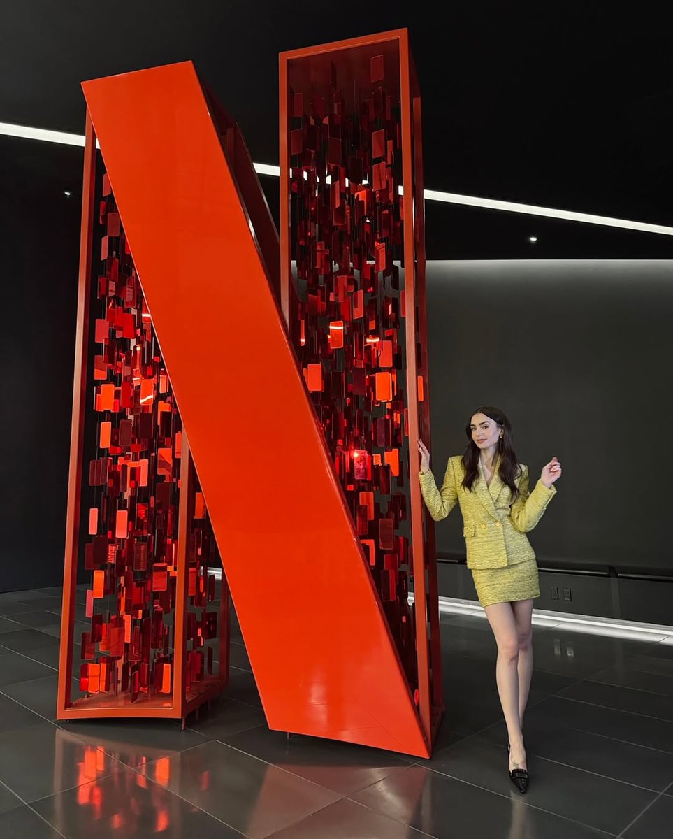 "# História de origem de Tudum? Claro, nossa garota Emily lançou isso. Voltou ao lugar de Emily para dizer que #Tudum está chegando ao <a href="/Netflix/">Netflix</a> Live em 31 de maio! ..." — Lily Collins via Instagram.