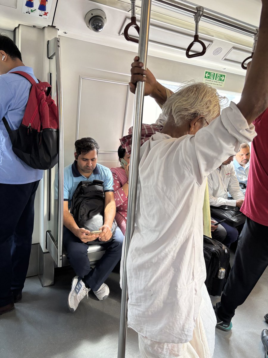 Shobhit_19's tweet photo. Professional ethics on full display — an elderly man is struggling to find a seat, and our DMRC employee is busy setting new records in apathy. Why bother standing up when ignorance is this comfortable? @OfficialDMRC https://t.co/MWp8EayAdl