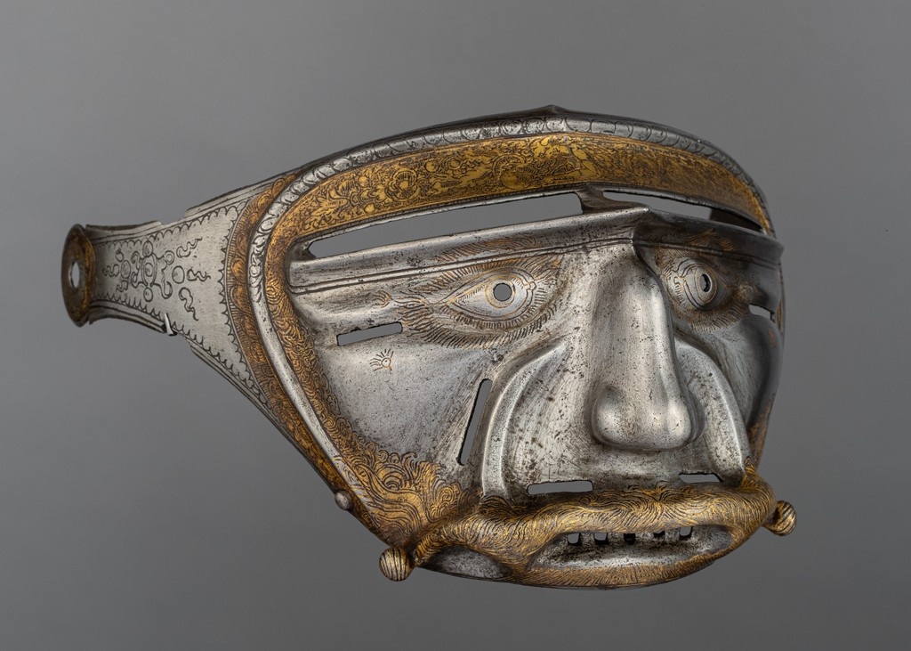 This decorative and unusual visor would have been substituted for a more utilitarian original, to be worn during festivals of Shrovetide (the period before Lent).

Attributed to Kolman Helmschmid, Helmet visor, c. 1515, <a href="/metmuseum/">The Metropolitan Museum of Art</a> 
#AntiqueOfTheDay #ArmsAndArmor #Helmets