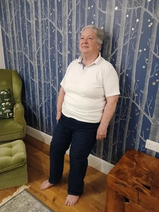 Image shows woman performing wall squat at home