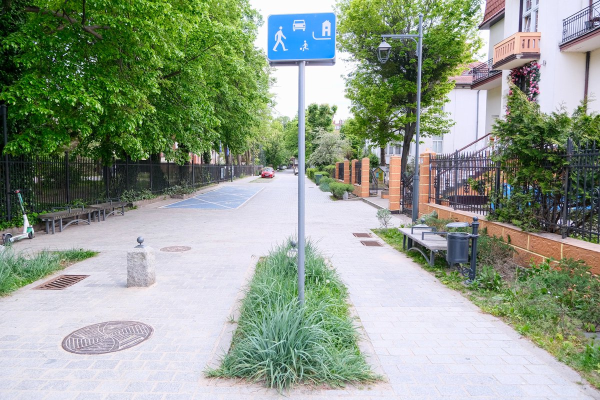 The woonerf or “living street” is spreading from the Netherlands across Poland, including in Sopot—just outside Gdańsk. Privileging pedestrians and calming traffic to 20 km/h, the name and elements are retained—removing the curb and adding texture, greenery, seating and lighting.