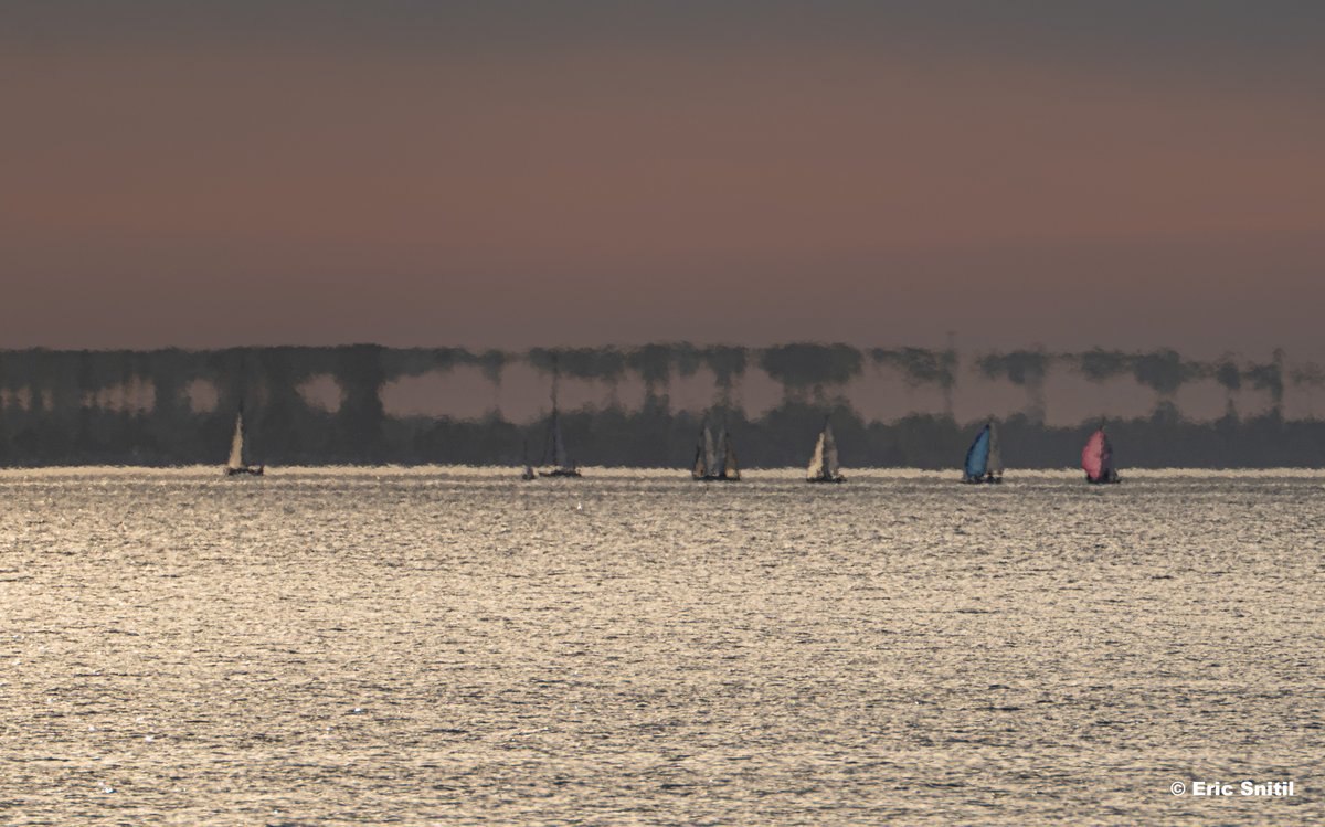Sailboats are out enjoying the evening on Lake Ontario. What the heck is going on behind them? This is a mirage, the byproduct of warmer air overtop the cooler water. This difference in air density causes objects, in this case distant land on the horizon, to be stretched and