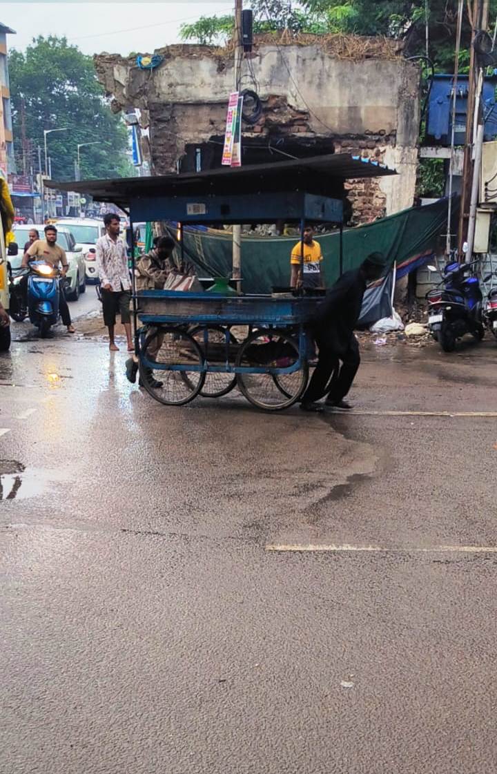 Good Evening Sir,  A. Shailaja WPC 12774 of traffic P.S. Bahadurpura is helping the old age person for pushing his push cart during raining at Bahadurpura X Road.