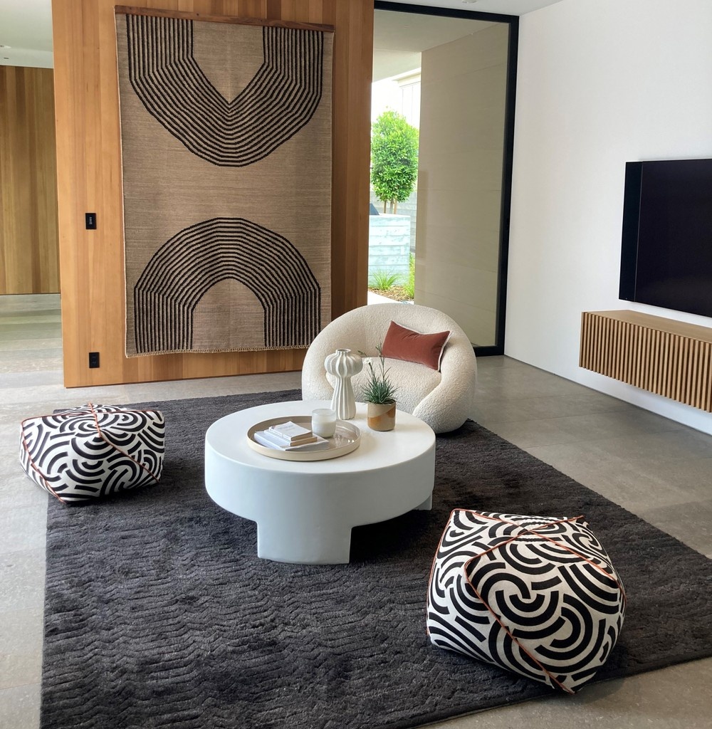 Crafting spaces that resonate. W/ our custom capabilities, designers enjoy the freedom of adding personality to their projects. See our Embrace swivel chair &amp; Origami ottomans in a chic black &amp; white textile w/ rust colored welt to match the accent pillow on our Embrace chair.