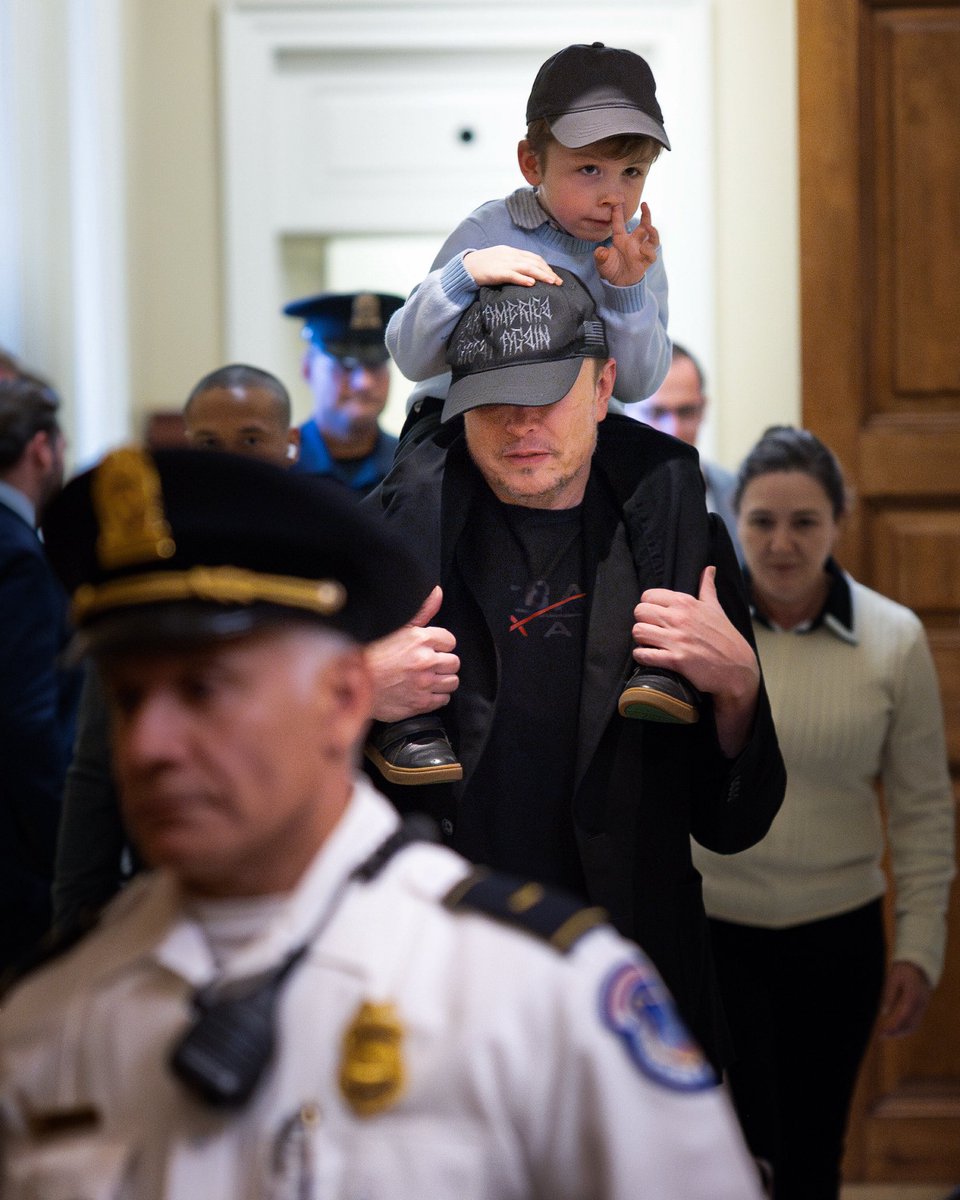 Elon Musk exits the U.S. Senate while carrying his son, X Æ A-12, following a meeting on Capitol Hill.
