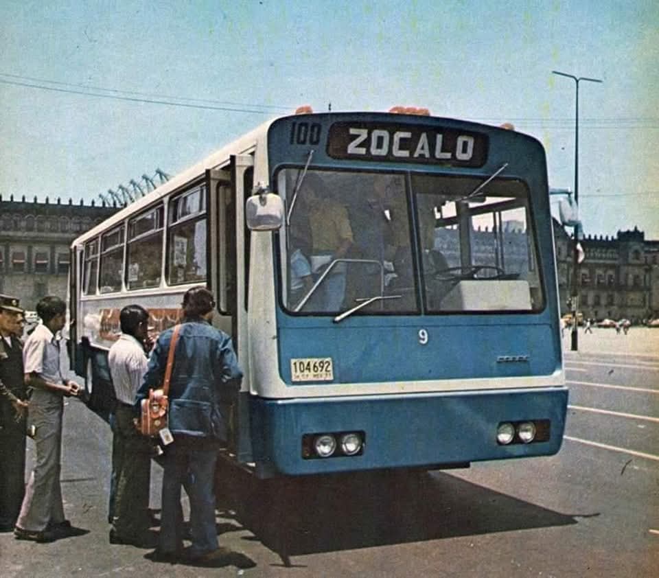 Abordando un autobús del transporte público frente al Zócalo en los años setenta. En el fondo se encuentra el Palacio Nacional.